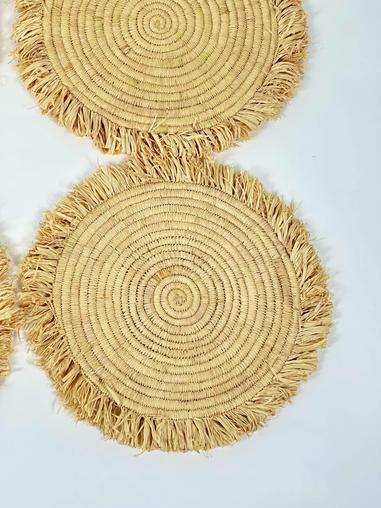Handmade round raffia placemats with fringed edges - Natural table setting..