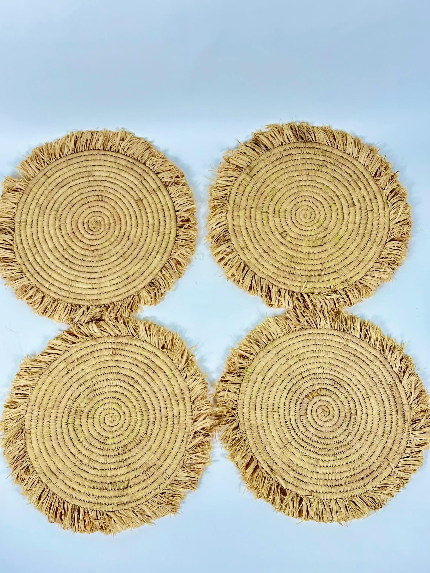 Handmade round raffia placemats with fringed edges - Natural table setting..